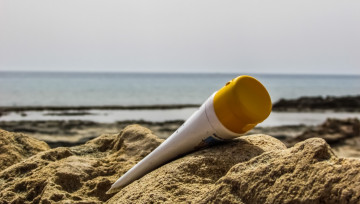 tube de crème solaire sur la plage dans le sable