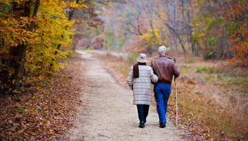 Photo d'un couple de seniors marchant sur un sentier forestier