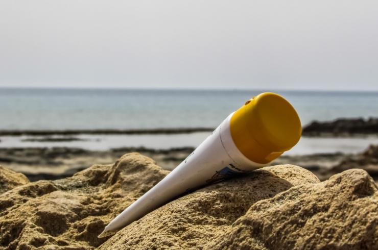 tube de crème solaire sur la plage dans le sable