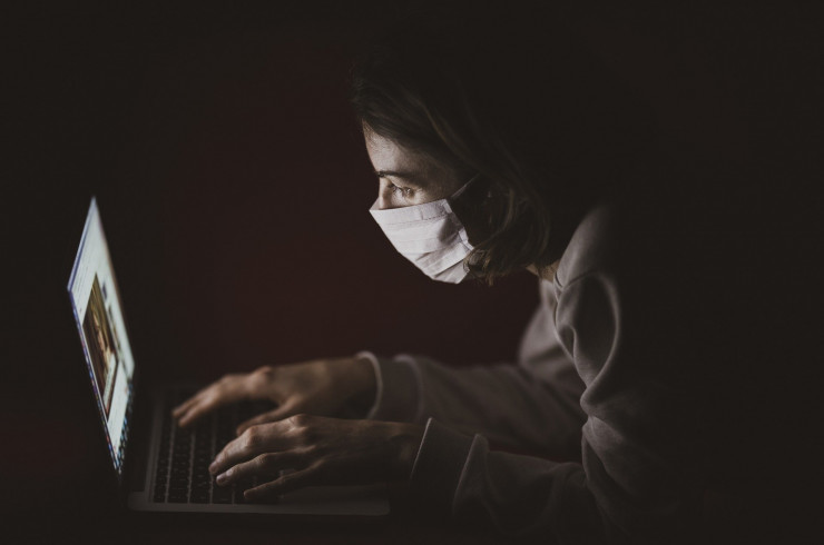 Image d'une internaute portant un masque devant son écran